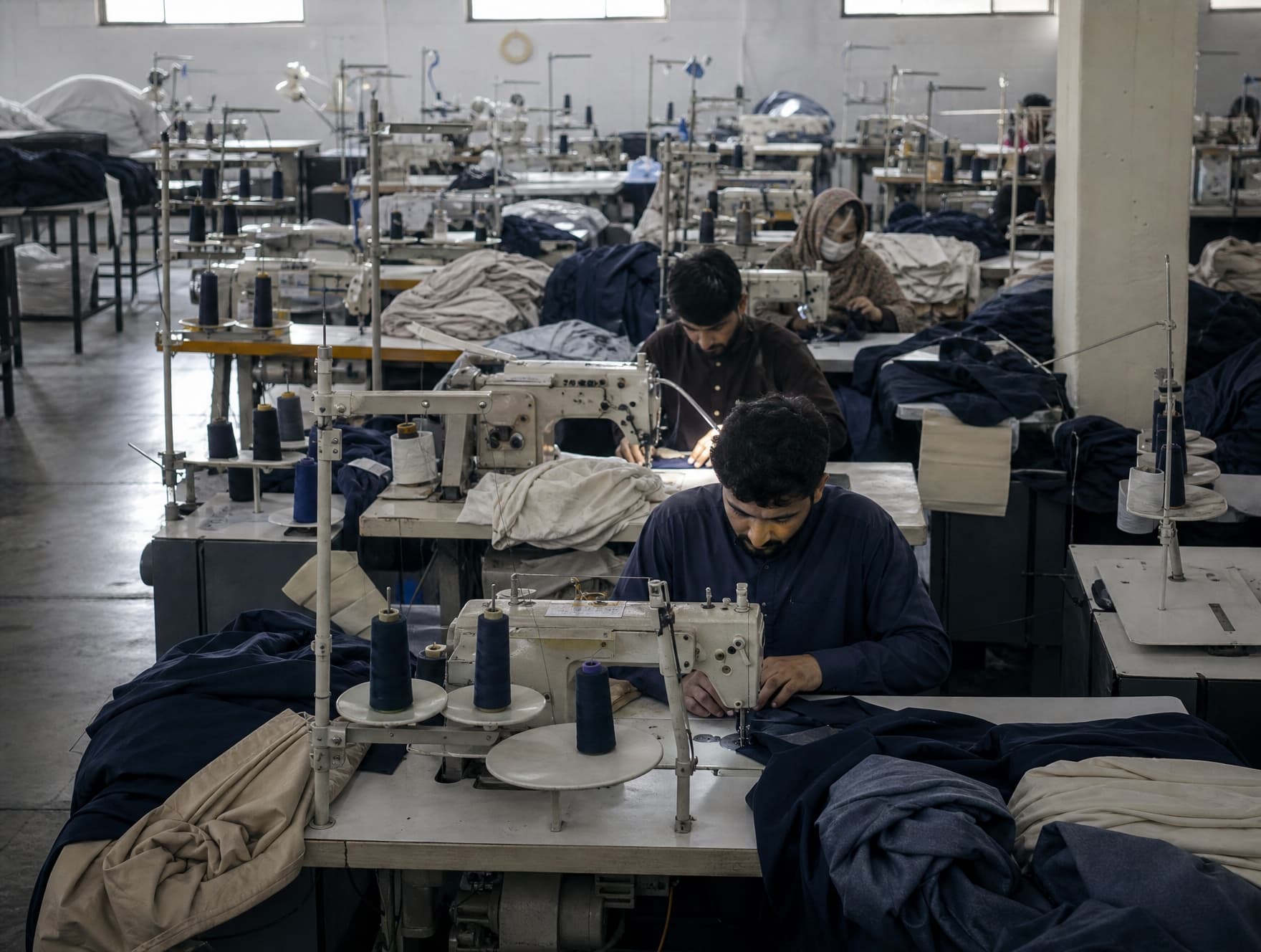 Wide view of a working production floor with sewing lines in depth