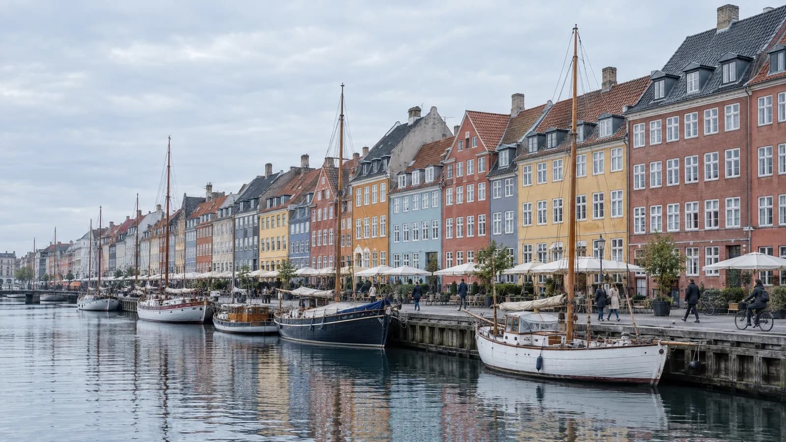 Illustrative view of the Nyhavn waterfront in Copenhagen with moored boats and narrow painted houses