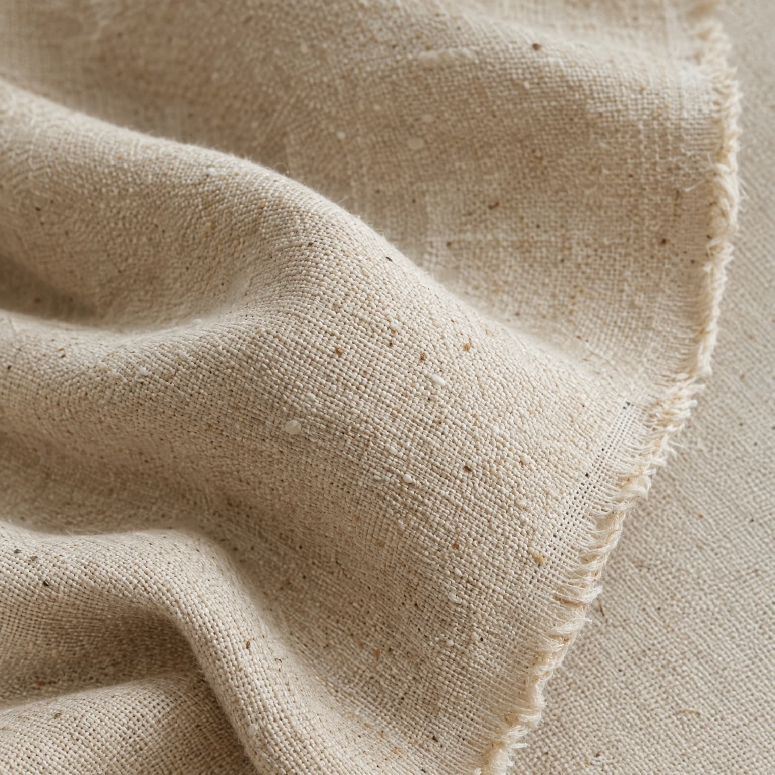 Macro detail of undyed organic cotton fabric with a frayed edge