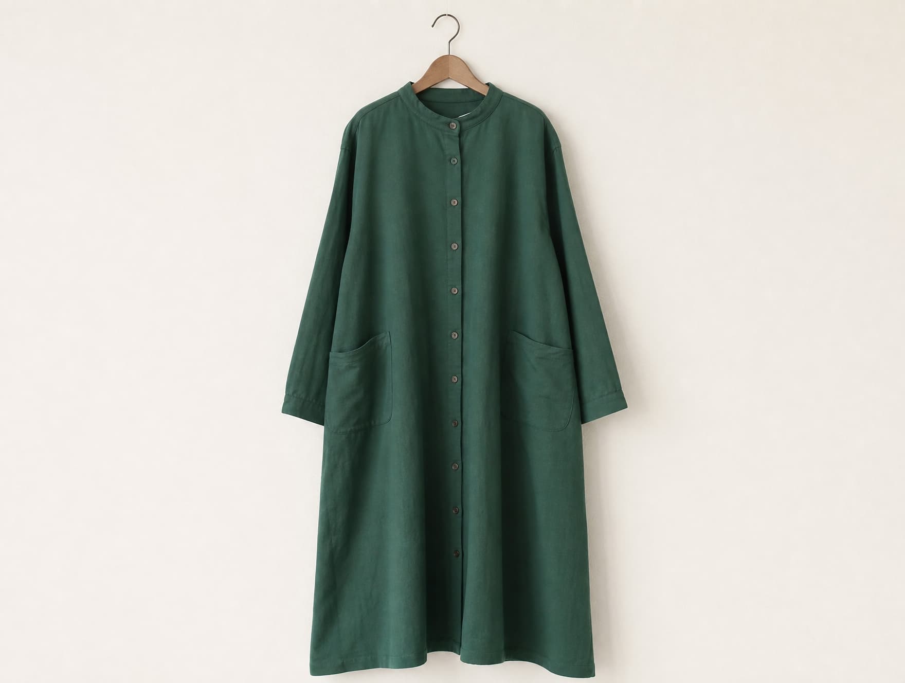 A modest shirt dress on a hanger, showing drape and finishing