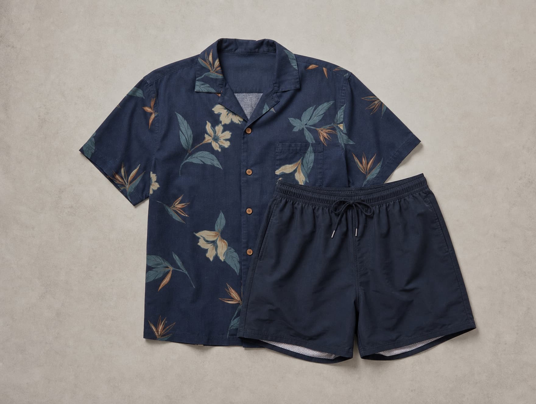 A printed resort shirt and swim shorts, shown flat